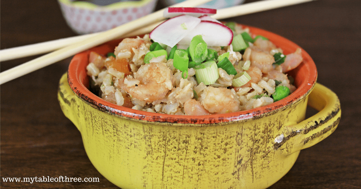 A serving of Shrimp Fried Rice in a yellow and orange stone bowl with chopsticks. 